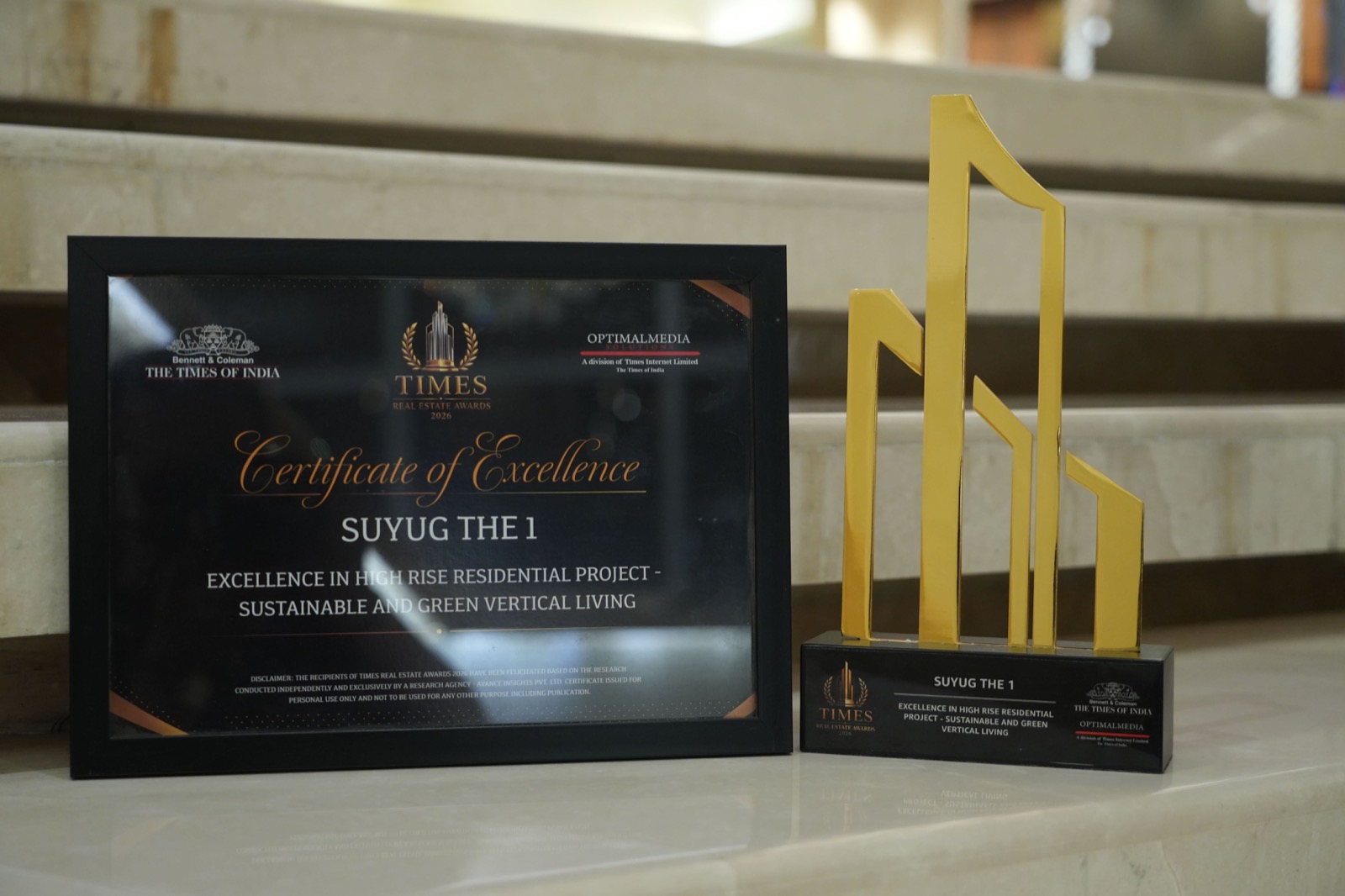 THE1's Times Real Estate Awards trophy beside its Certificate of Excellence for 'Excellence in High Rise Residential Project — Sustainable and Green Vertical Living'