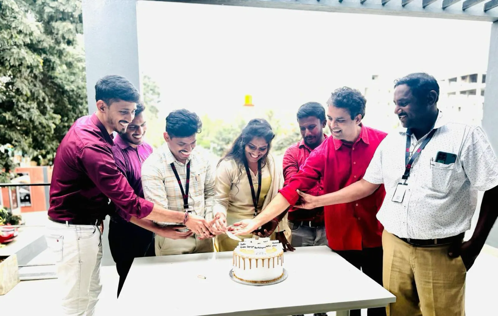 Seven pairs of hands on the knife for the cake.