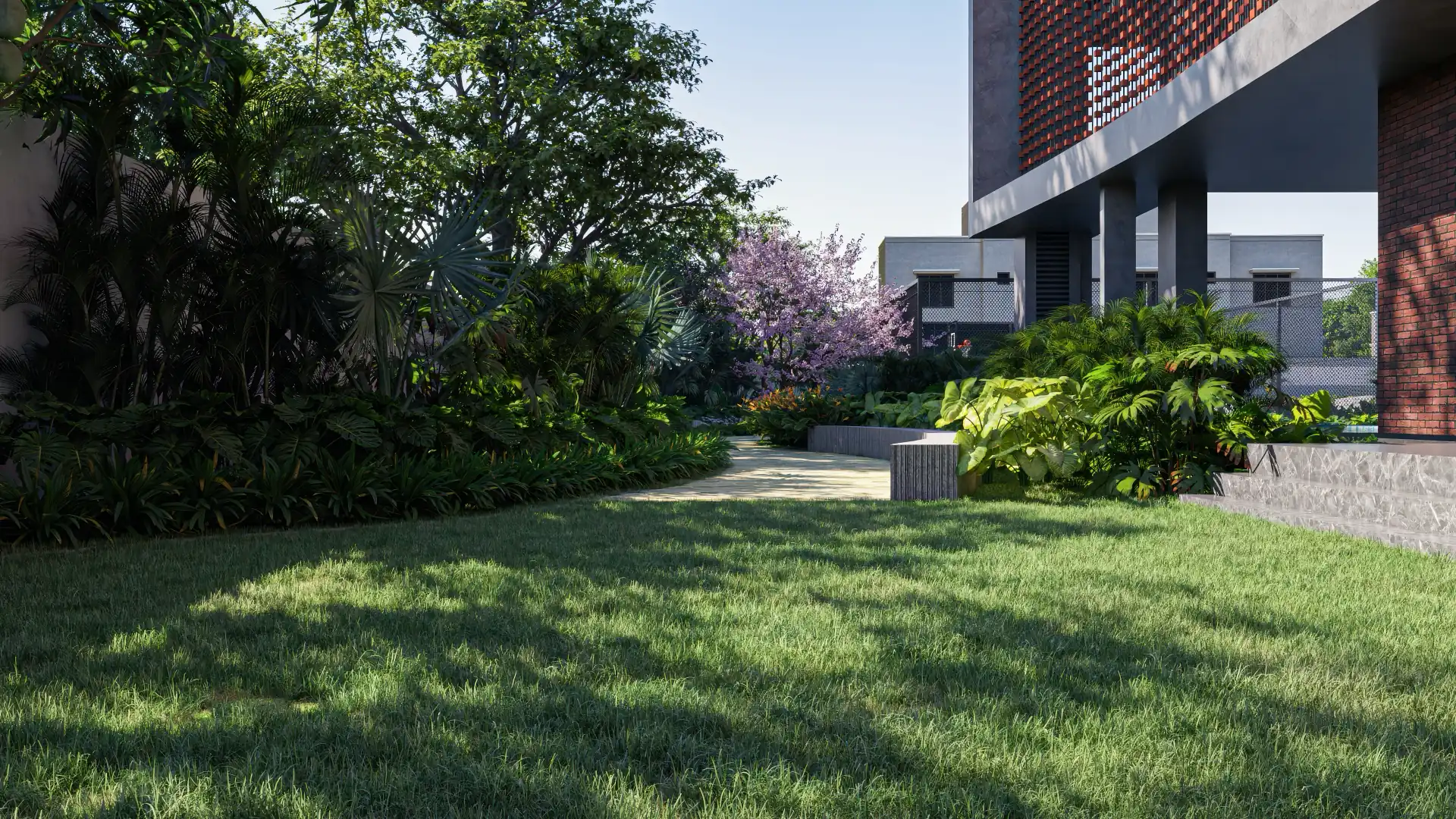 Shaded lawn and layered planting beside the clubhouse, with a blossoming tree and a curving path